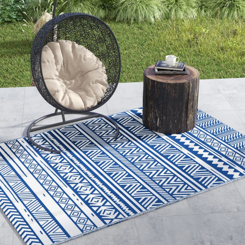 Dark blue and white patio rug with egg chair and log table