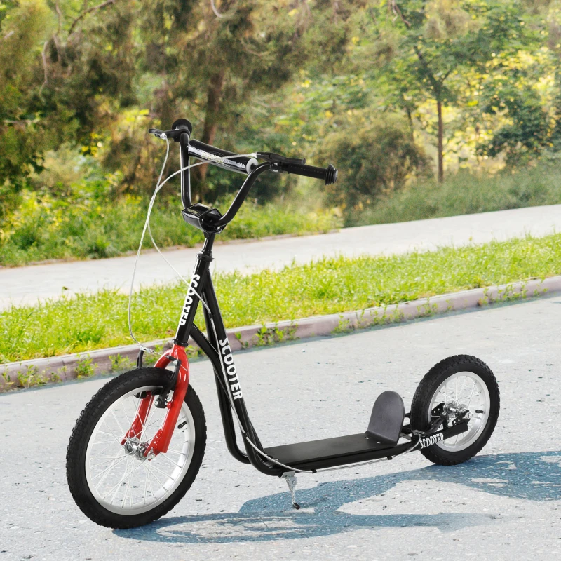 Black kick scooter with red fork parked on outdoor pathway.