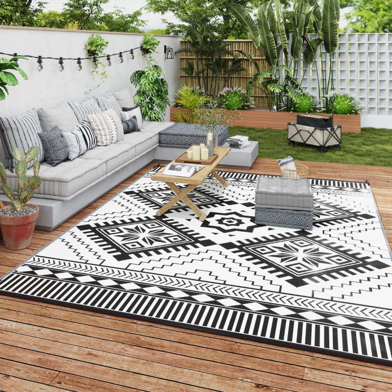 Black and white toothed rhombus reversible outdoor rug on patio with sofa set
