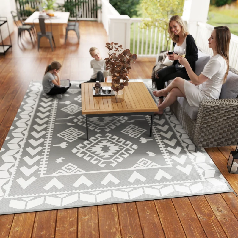 Grey and white rhombus reversible RV rug on patio with family