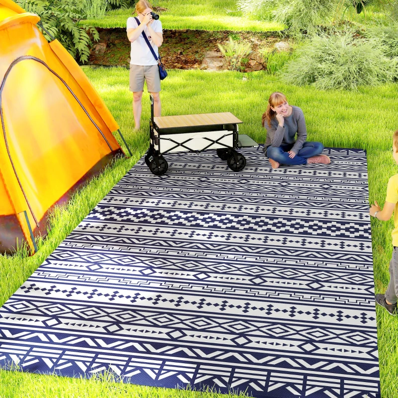 Large blue geometric outdoor rug beside tent with family camping