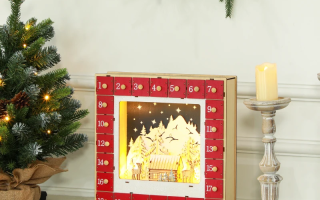 Wooden lighted advent calendar with Christmas trees, wreath, and candle décor.