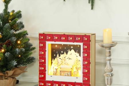 Wooden lighted advent calendar with Christmas trees, wreath, and candle décor.