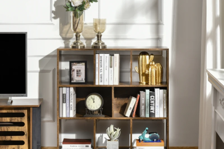 Rustic brown storage shelf placed beside a TV stand, decorated with books and ornaments.