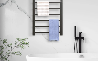 Modern black towel warmer mounted near white bathtub on marble wall