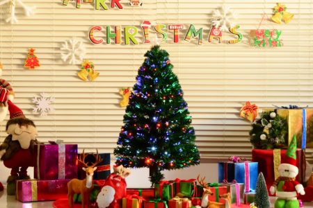 Decorated pre-lit Christmas tree glowing with colorful lights and holiday gifts underneath.