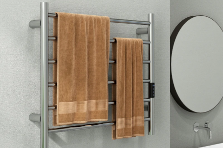 Modern bathroom with chrome towel warmer holding clean brown towels.