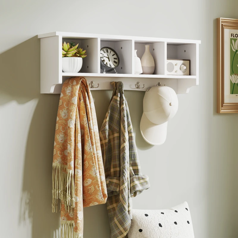 White wall-mounted coat rack with four shelves and hooks holding scarves, shirts, and a cap.