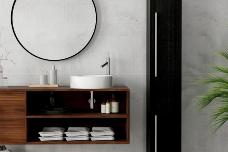 Minimal beige bathroom with towel rack, vanity, laundry basket, and bath mat.