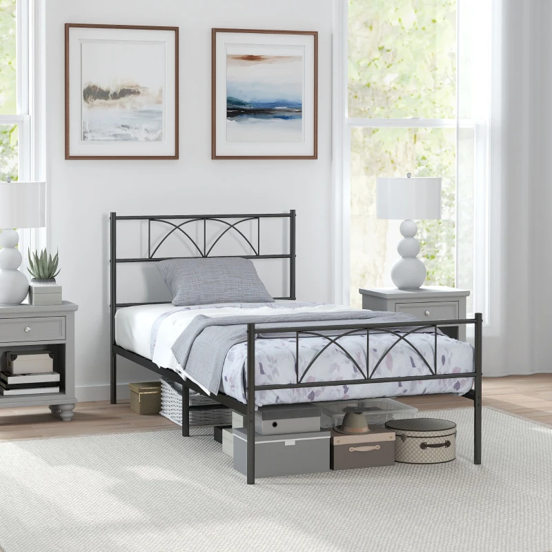 Black metal twin bed frame with storage boxes beneath and soft bedding.