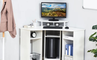 Compact white corner desk with computer setup and organized office supplies.