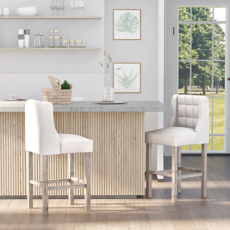 Beige tufted bar chairs placed at kitchen counter with light wood paneling and decor.