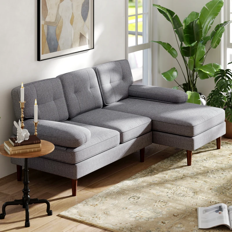 Grey sectional sofa with chaise lounge beside indoor plants in sunlit modern living room.