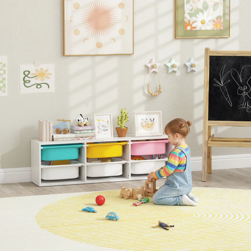 Toddler playing beside colorful nursery toy bins and chalkboard
