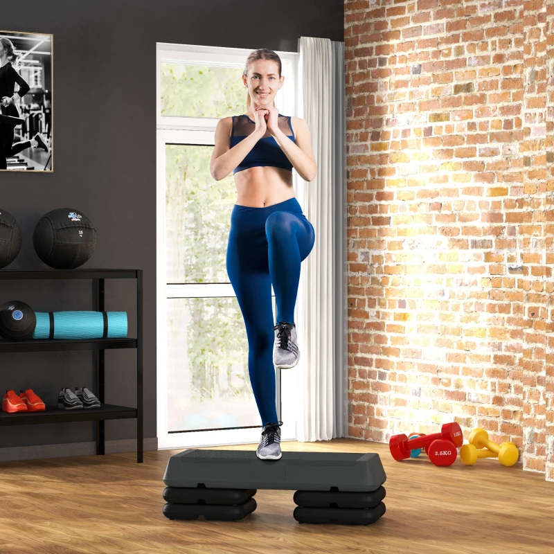 Woman doing step workout on aerobic platform in home gym.