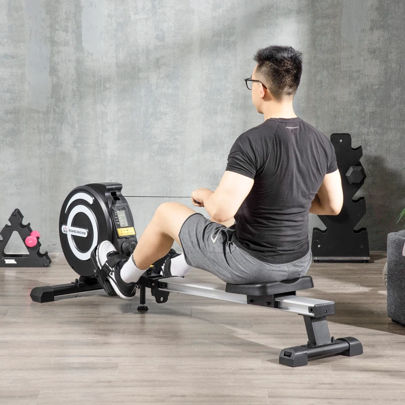 Man using magnetic rowing machine for full-body workout indoors.