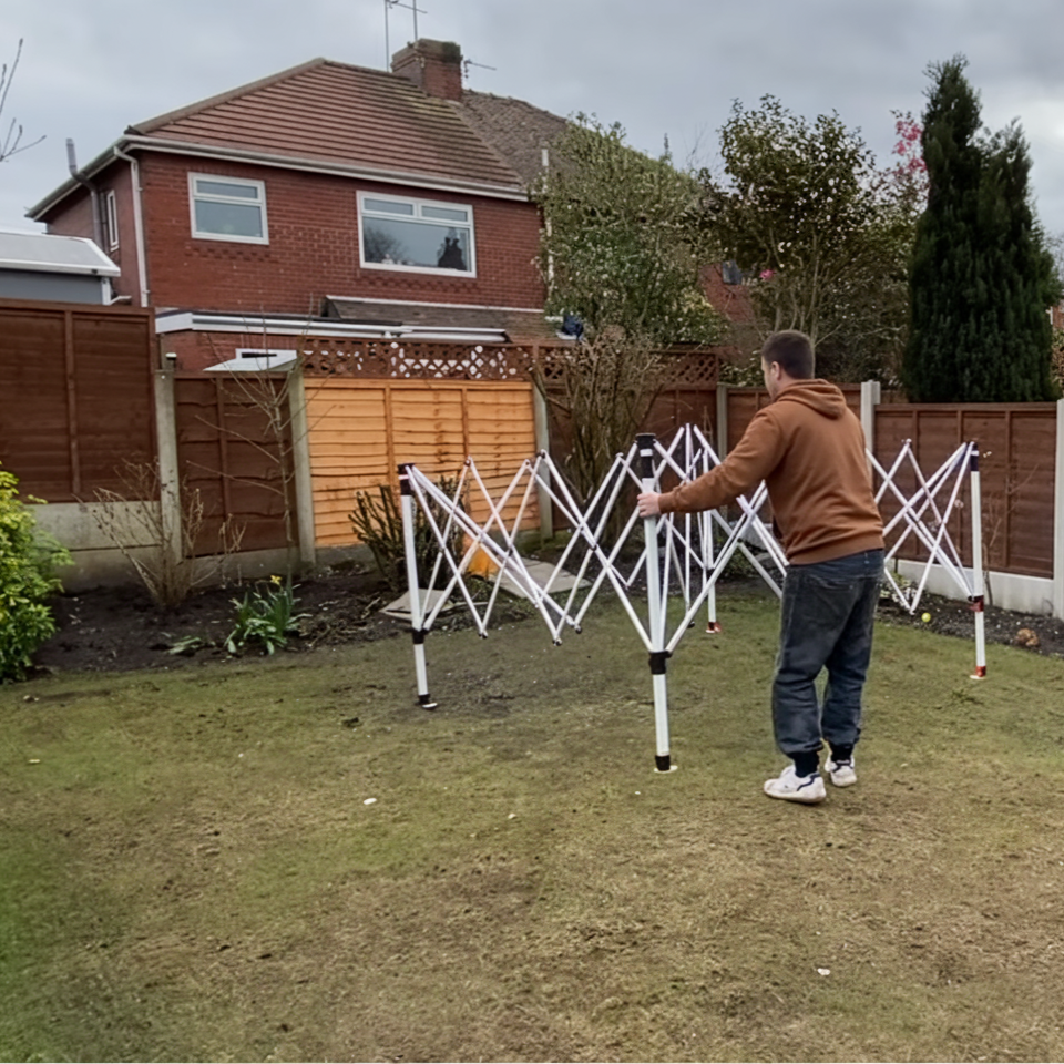 Man unfolding metal frame of pop-up canopy tent.