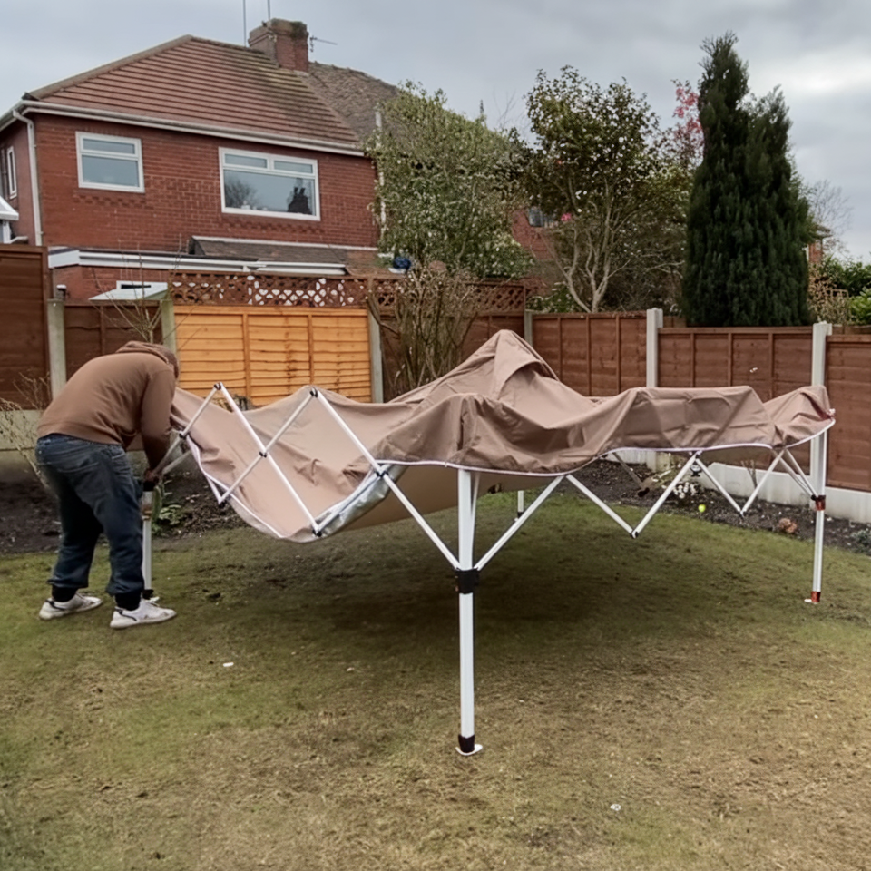 Person expanding white metal tent frame before setup.