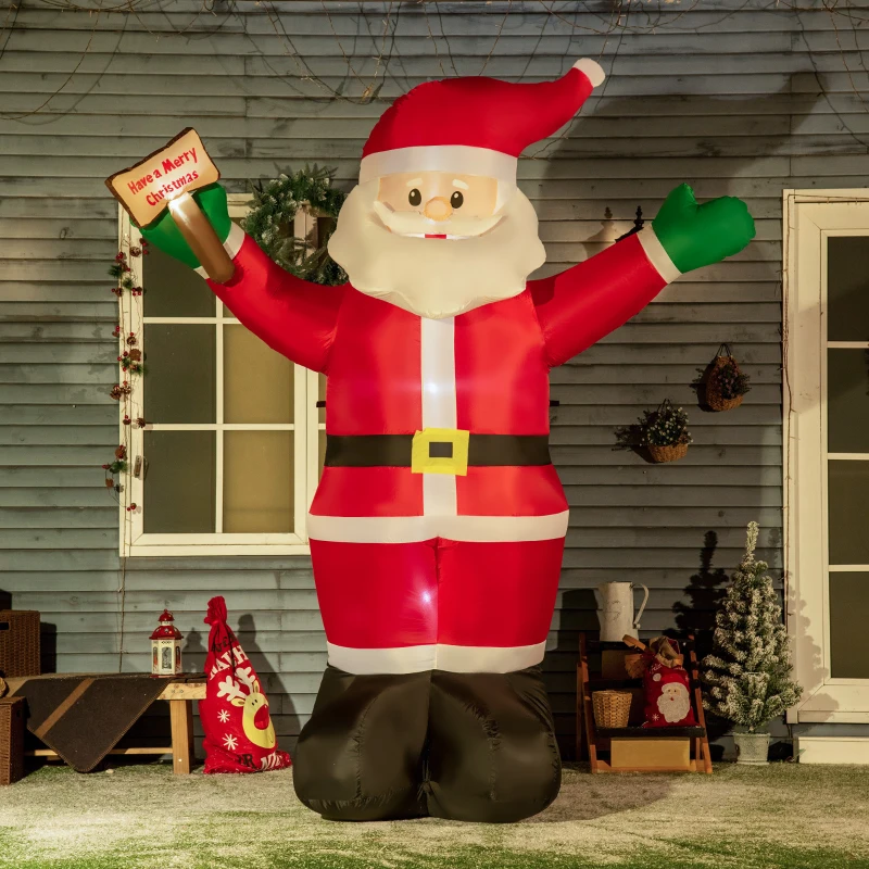Giant inflatable Santa holding Christmas sign in snowy yard.