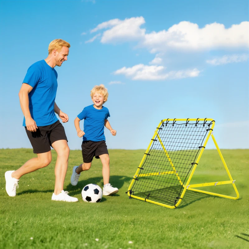 Father and son playing soccer with rebounder net on grassy field.