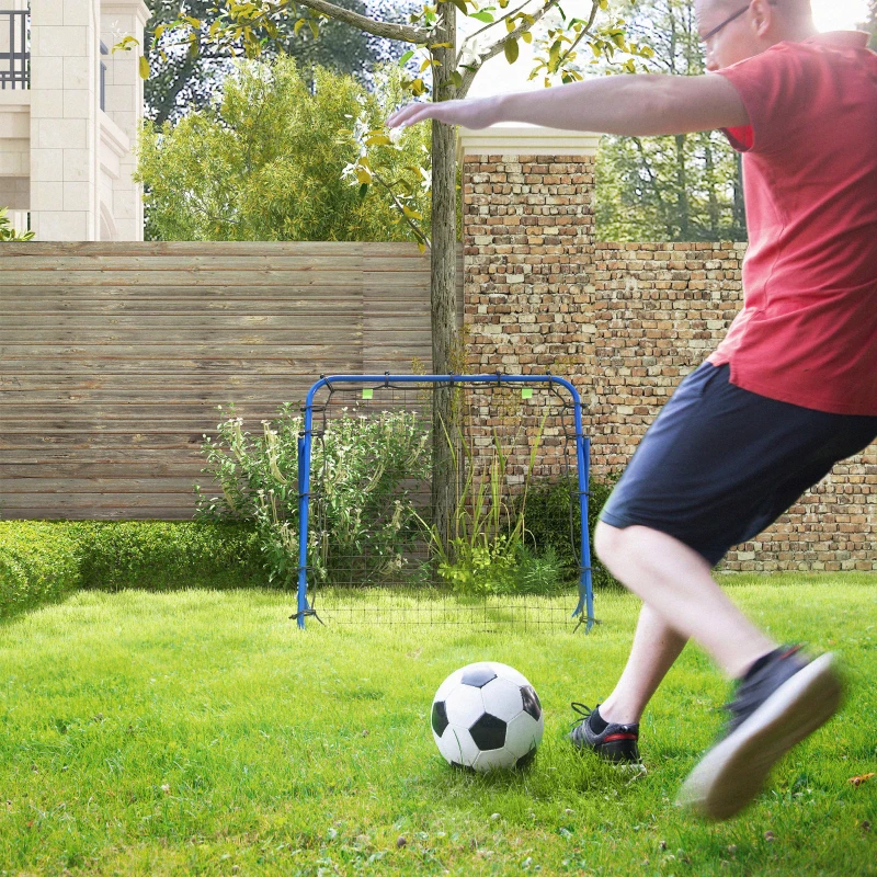 Man kicking soccer ball toward blue rebounder net in backyard.