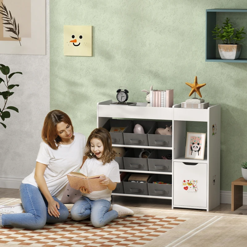 Mother and child reading beside white toy organizer with fabric bins.