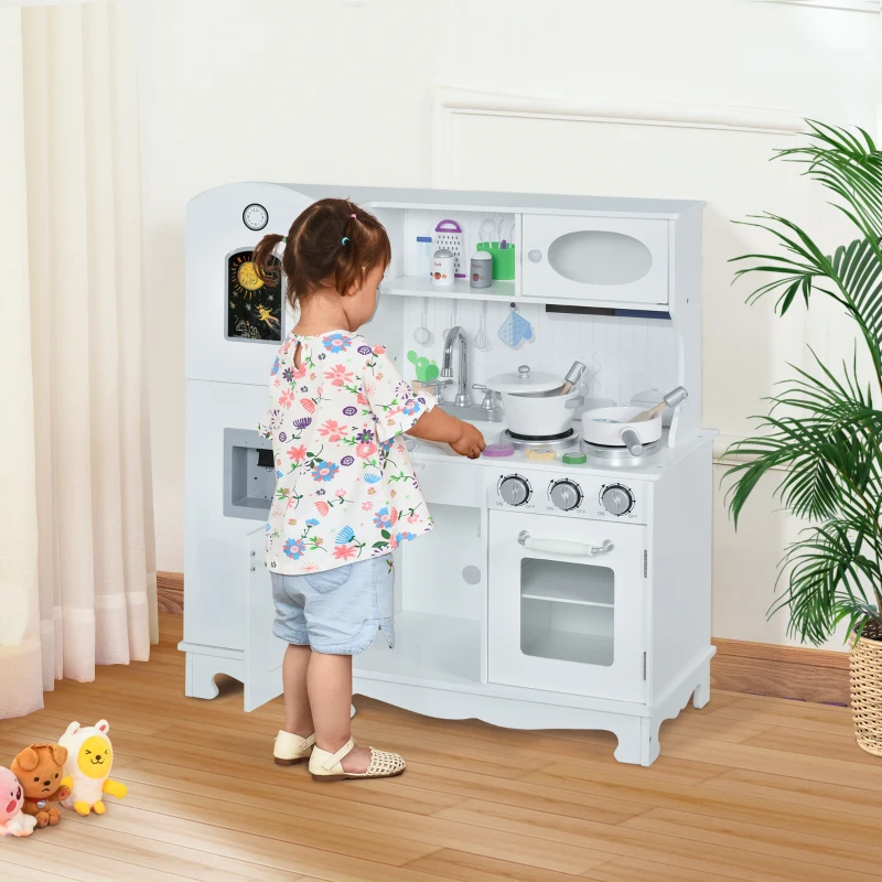 White toy kitchen with pretend phone, sink, and accessories in nursery.