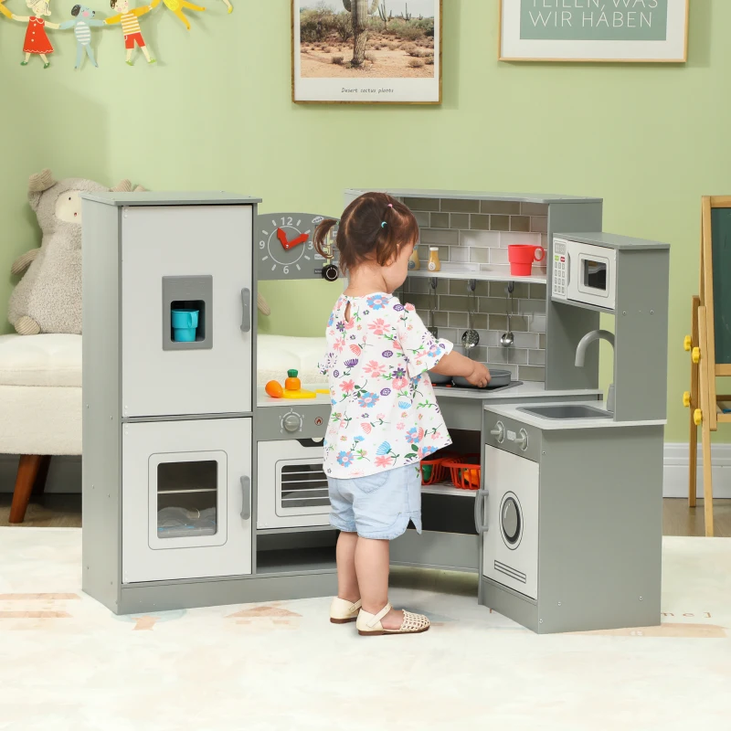 Toddler playing with gray corner toy kitchen featuring oven and fridge.