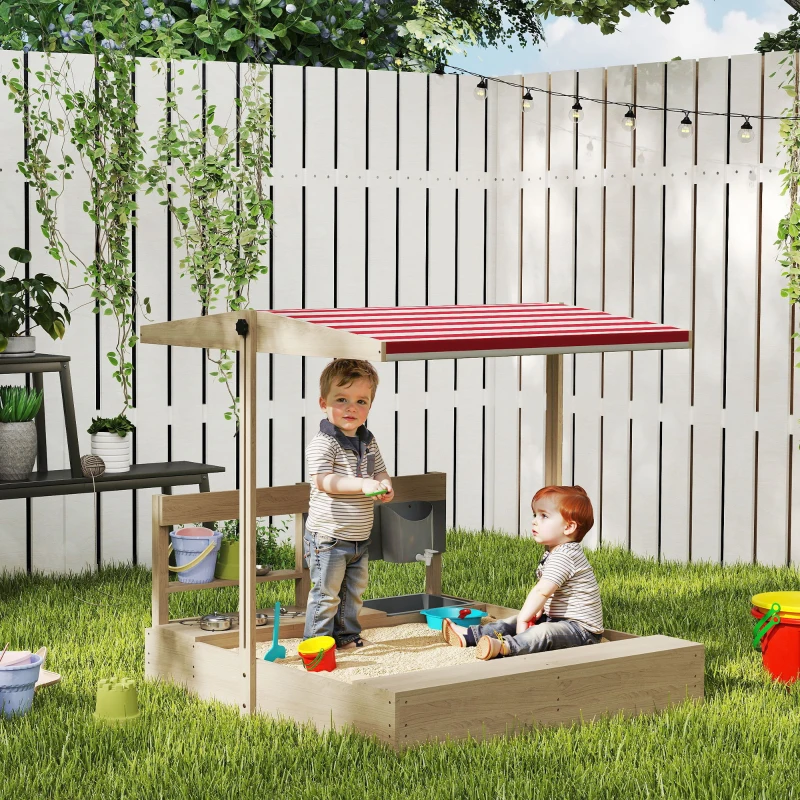 Two children playing with sand and water under shaded sandbox canopy.