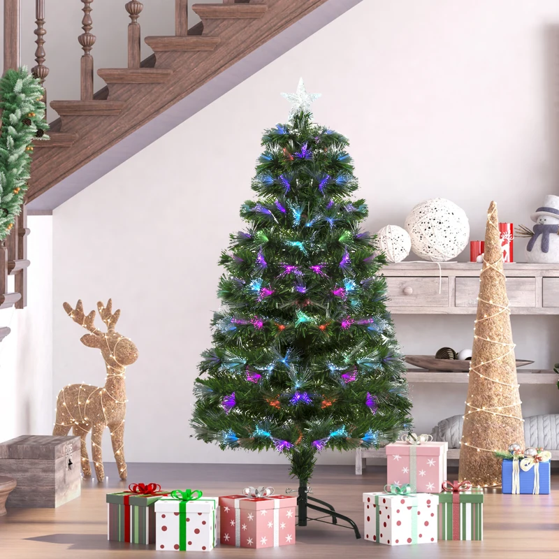 Compact spruce Christmas tree with multicolor fiber-optic lights beside stairs and gift boxes