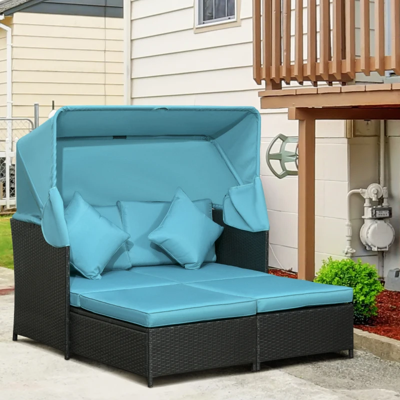 Black rattan daybed with turquoise canopy and cushions in a backyard.