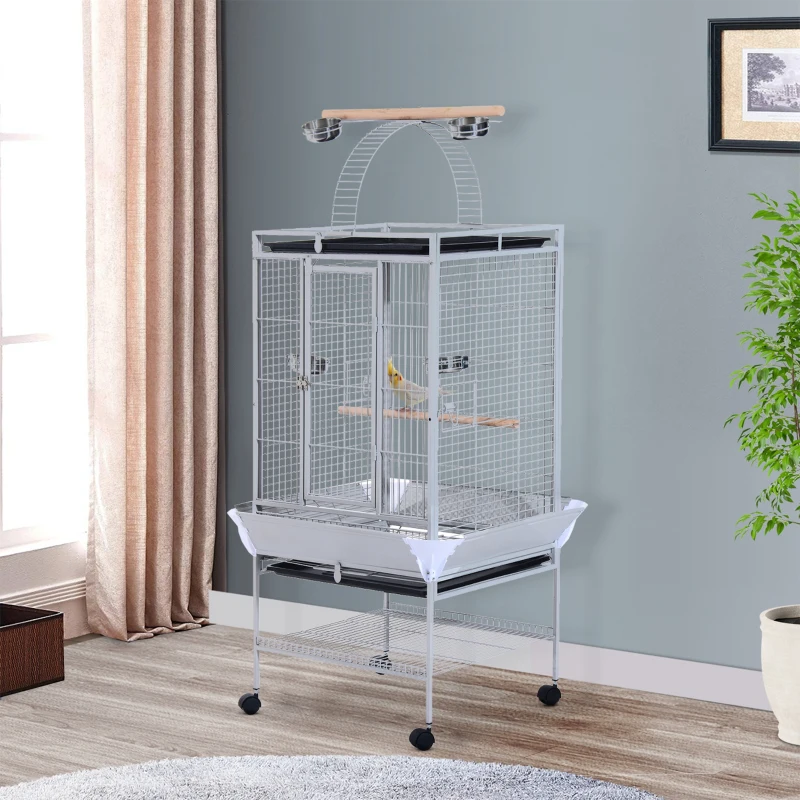 Spacious gray bird cage on wheels with perch playtop and feeding bowls in bright room.