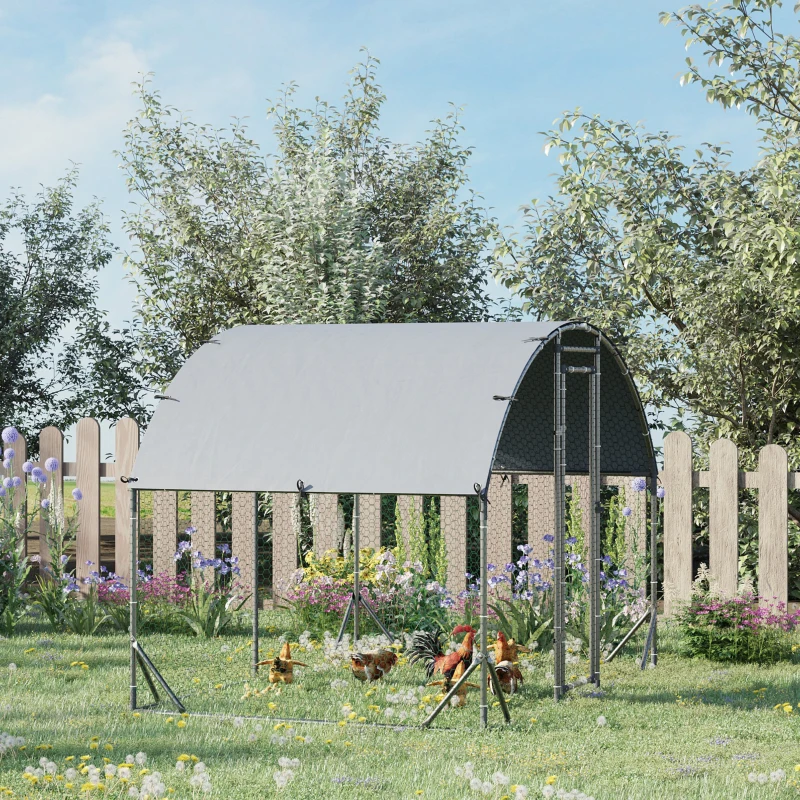 Walk-in chicken coop with tall frame and grey cover protecting hens in grassy garden.