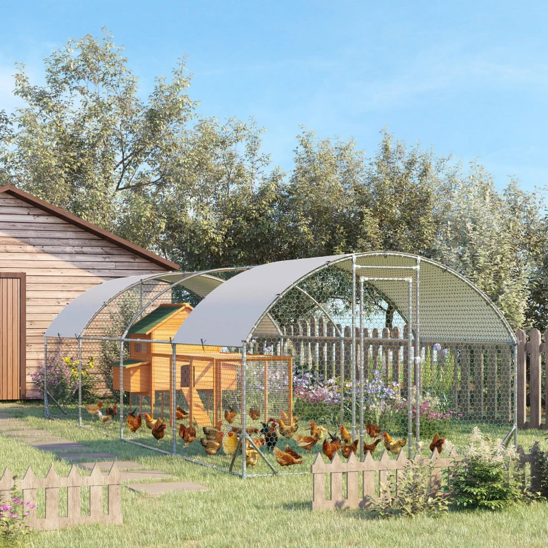 Large galvanized metal chicken coop with shaded roof and multiple hens inside fenced yard.