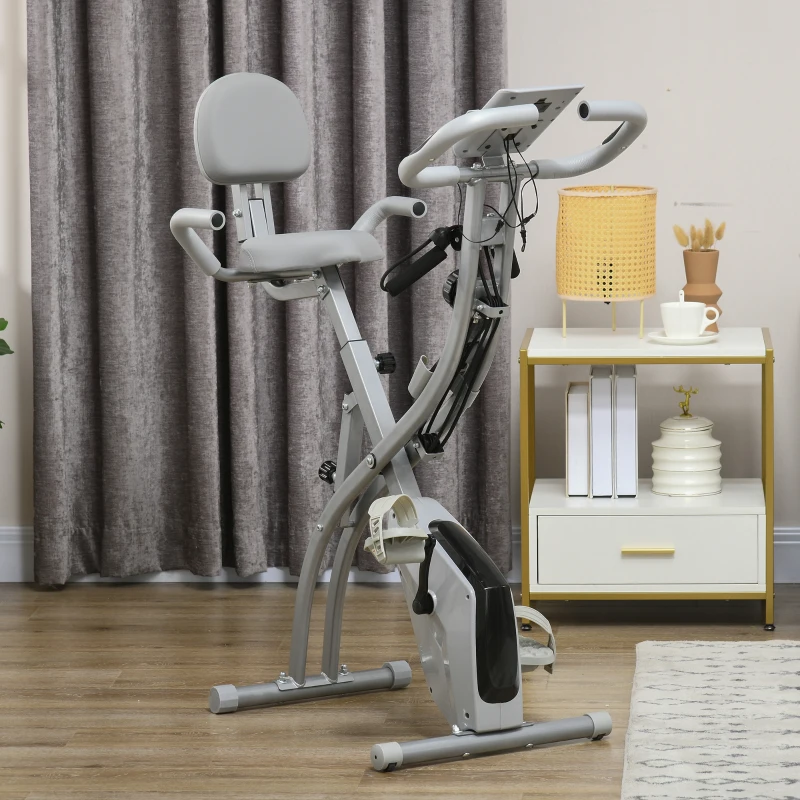 grey foldable stationary bike set up in cosy living room interior.