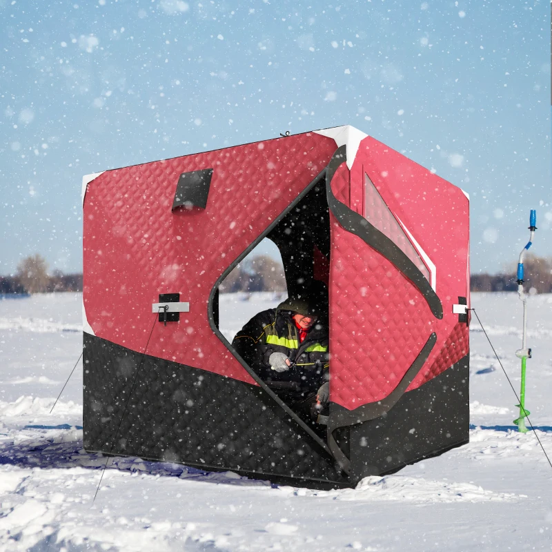 Red insulated ice fishing tent in snowfall with person inside.