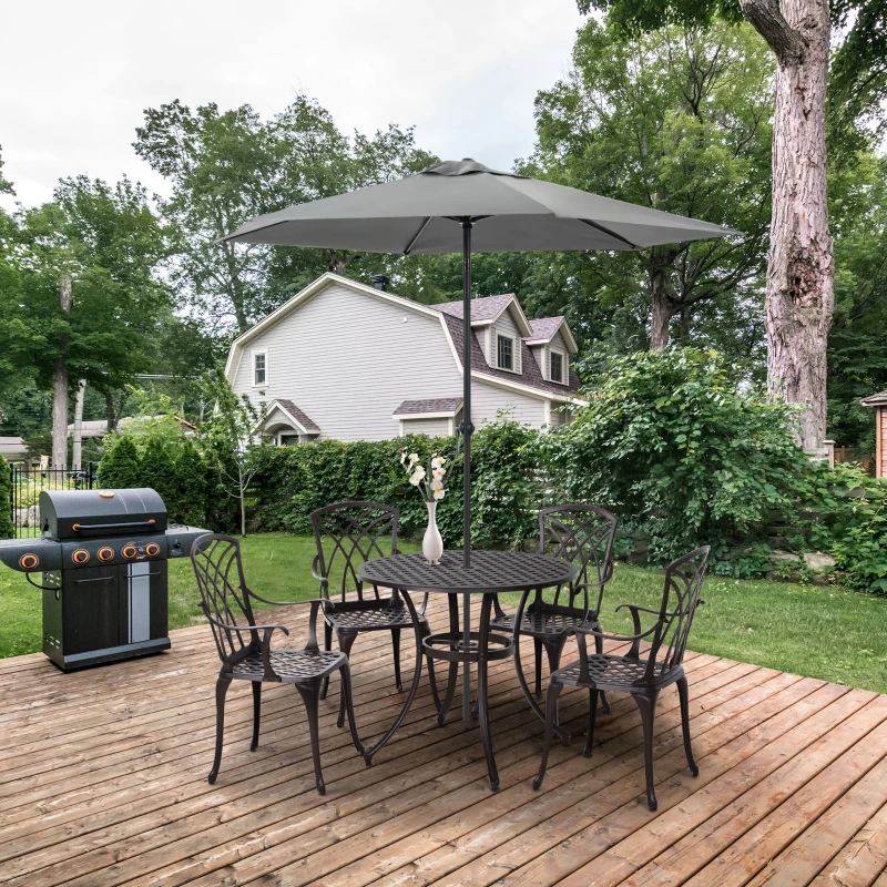 Cast aluminium outdoor dining set with umbrella on wooden deck beside garden grill.