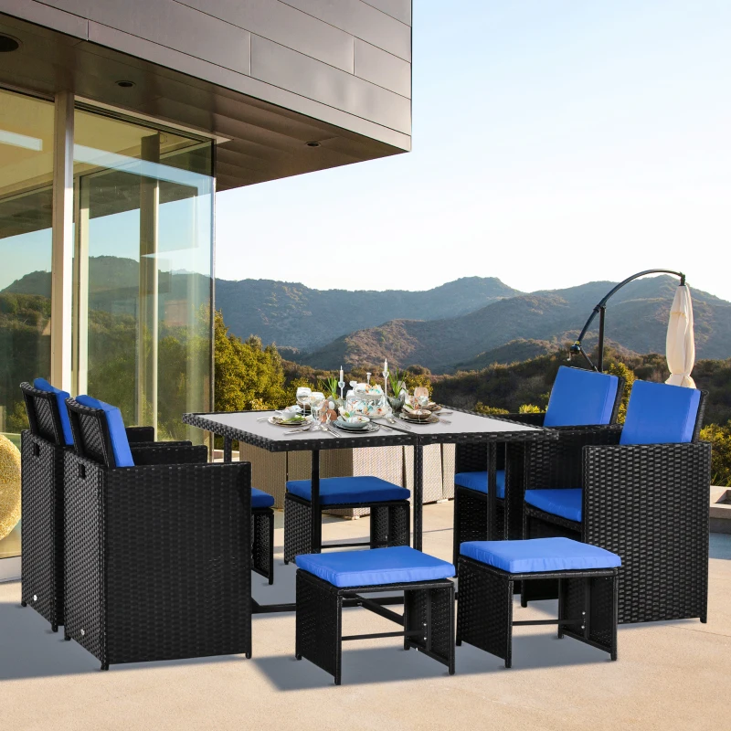 Black rattan outdoor dining set with blue cushions on modern patio terrace.