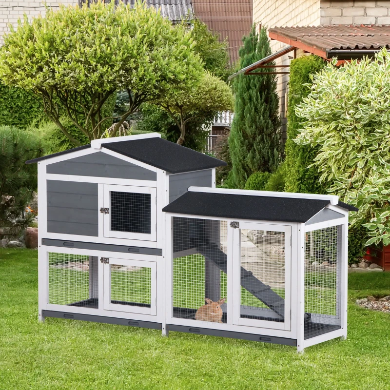 Large outdoor grey wooden rabbit hutch with run area and black asphalt roof.