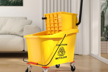Smiling woman mopping living room floor using yellow mop bucket and wringer.