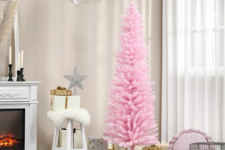 Soft pink Christmas tree with glowing lights and gold ornaments in a cosy living room.