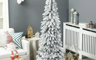 Tall flocked Christmas tree decorated with gifts and ornaments in cosy living room.