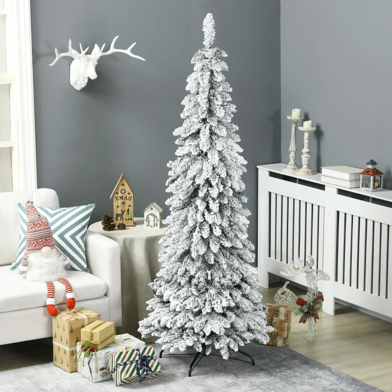 Tall flocked Christmas tree decorated with gifts and ornaments in cosy living room.