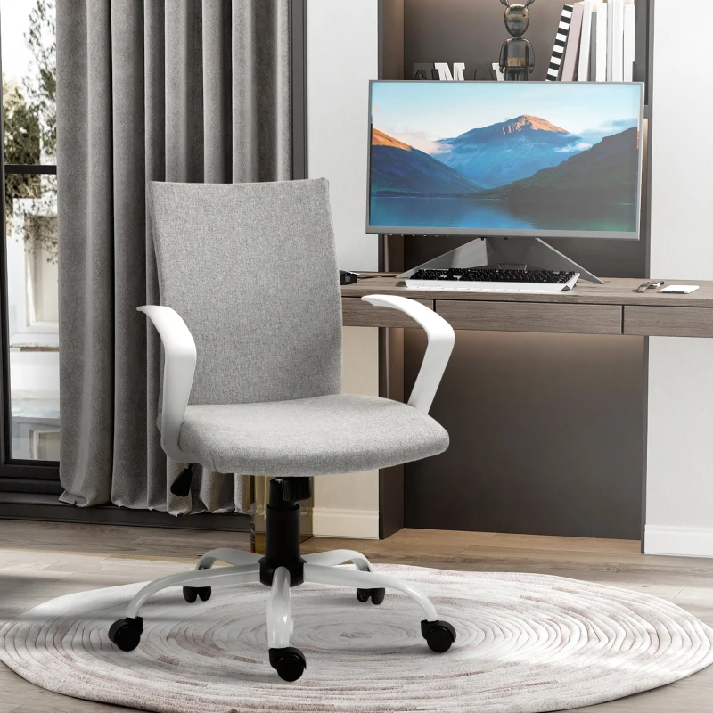 Grey linen mid back office chair with white arms and rolling base near modern desk.