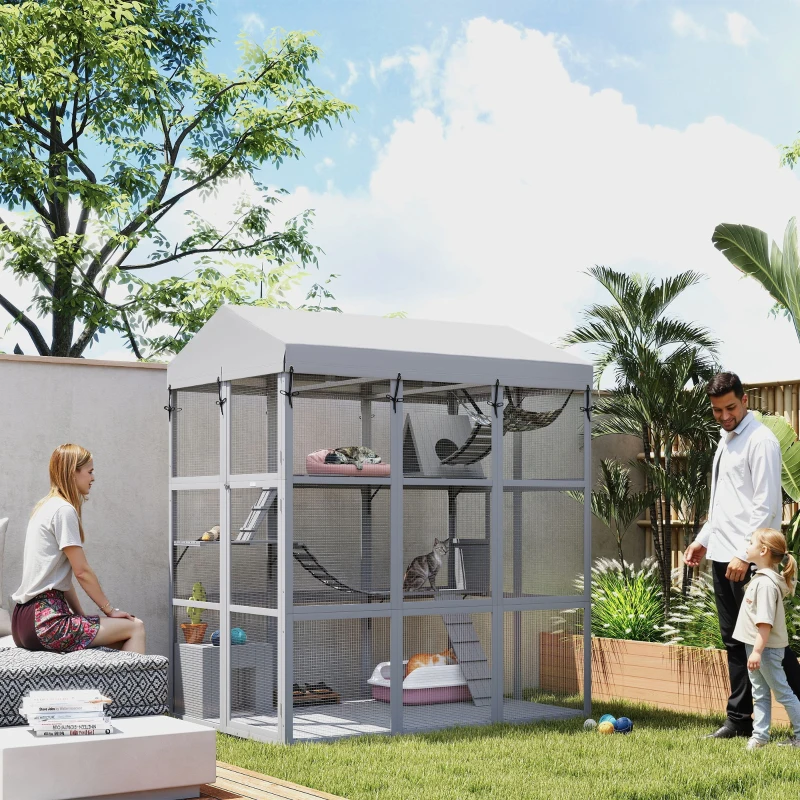 Outdoor wooden catio with canopy roof, ramps, hammocks, and cats resting in a garden space.