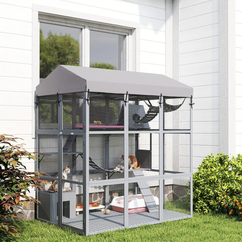 Grey raised outdoor catio with multiple levels and canopy placed by house window.