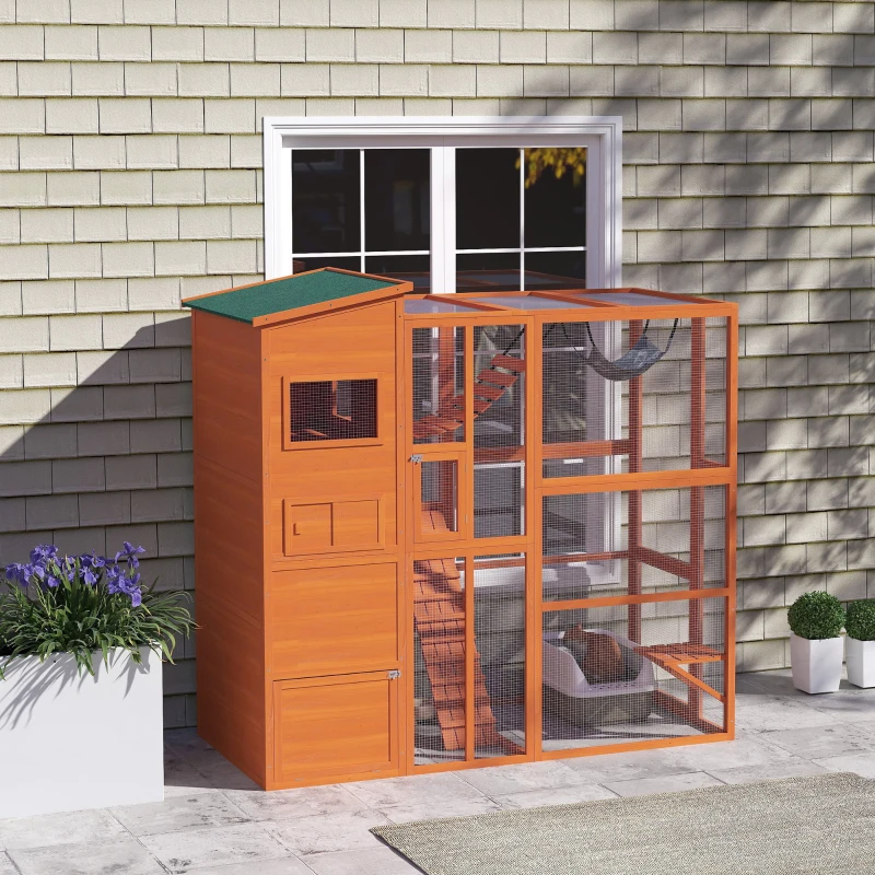 Orange wooden outdoor catio with ramps, hammock, and cats relaxing beside house wall.