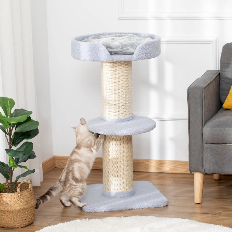Cat scratching a tall sisal post on a two-platform cat tree with a soft top perch.