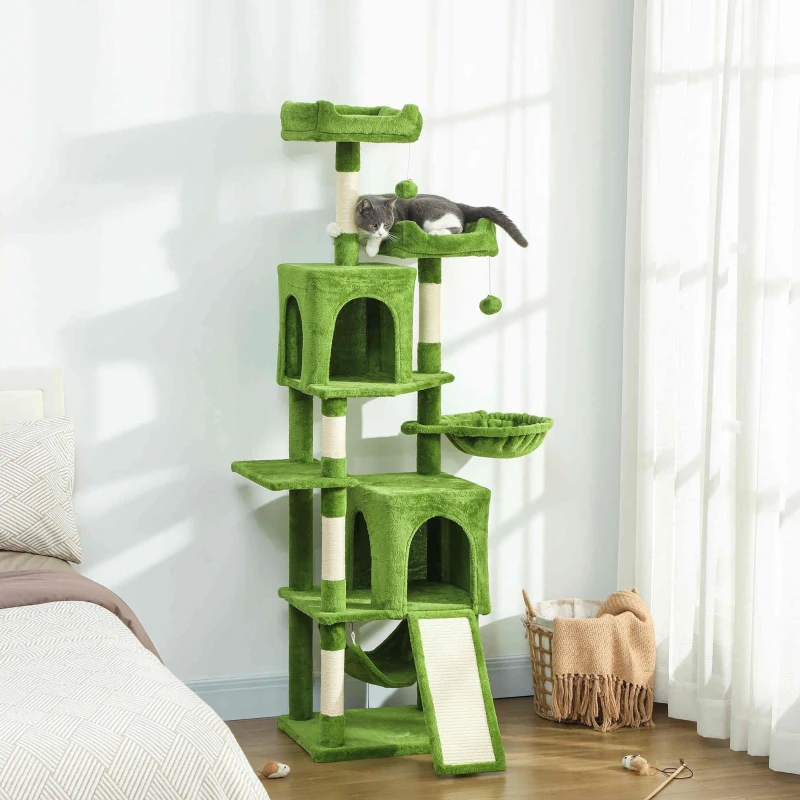 Green multi-level cat tree with condos, hammock, ramp, and a cat lounging on the upper perch.