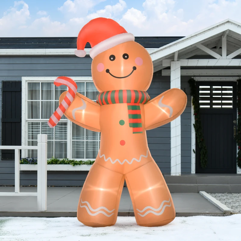 Large gingerbread man inflatable with candy cane outside a grey house in winter.